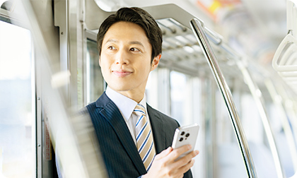 電車内でスマートフォンを利用するビジネスマン